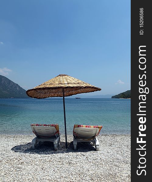 Two chairs, umbrella and sea. Two chairs, umbrella and sea