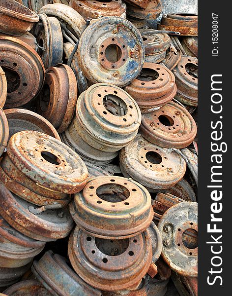 A large pile of rusty automobile disc brake rotors at a salvage yard. A large pile of rusty automobile disc brake rotors at a salvage yard.