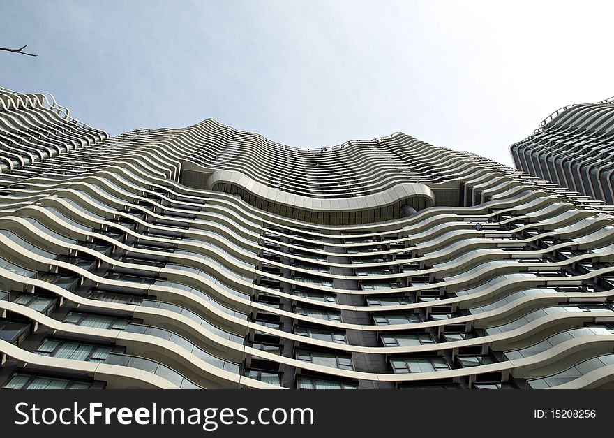 Cityscape of Urban building with windows in wave pattern under blue sky