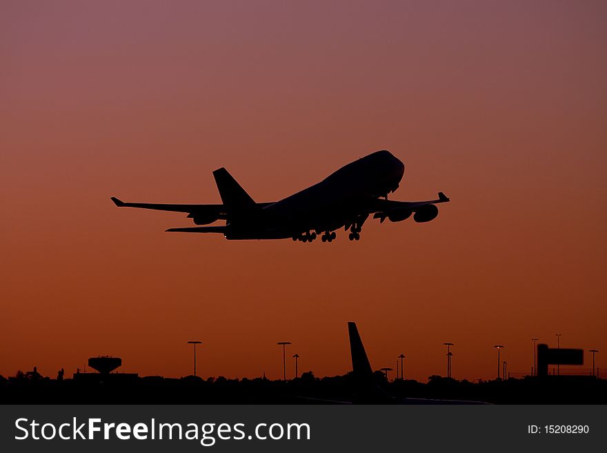 Boeing 747 jumbo jet taking off at dusk.