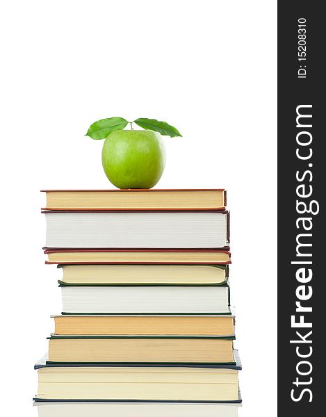 Stack of books and green apple isolated on white background