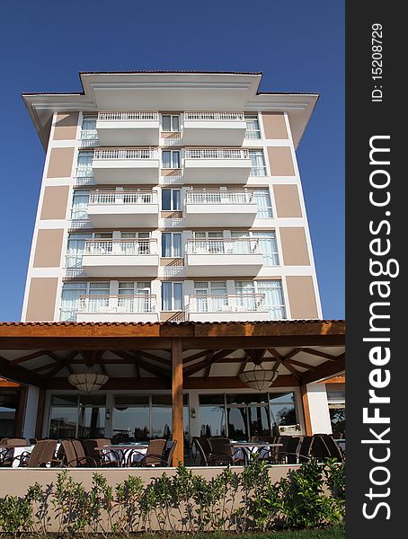 Beach hotel with outdoor restaurant against bright blue sky