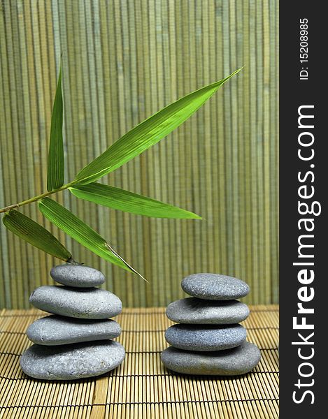 Bamboo leaf and a stack of stones on a bamboo mat. Bamboo leaf and a stack of stones on a bamboo mat