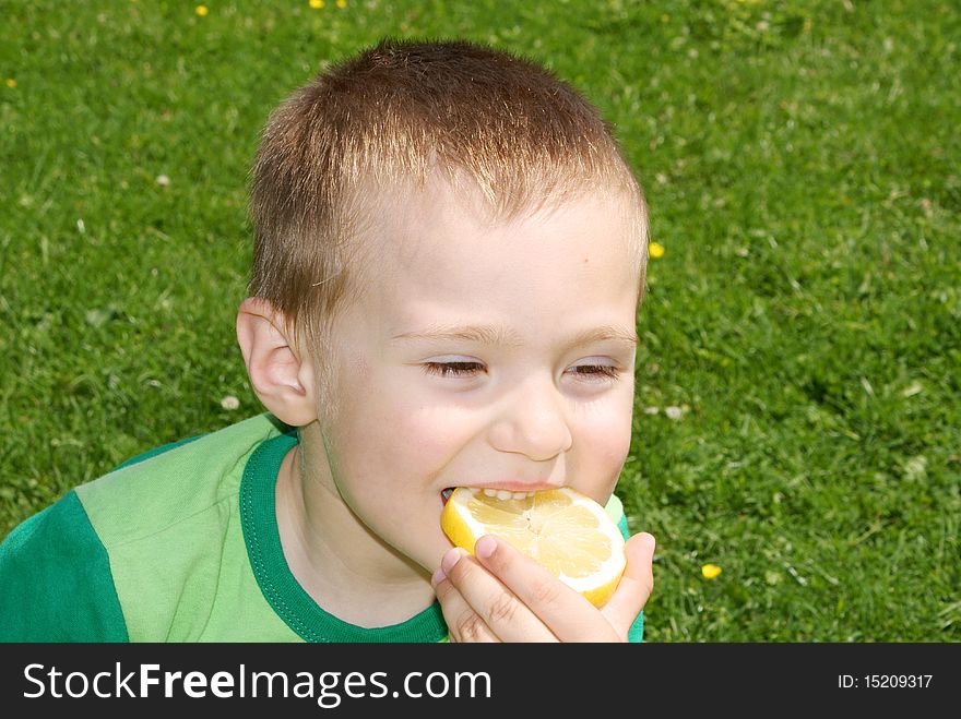 A child with pleasure eating lemon grass background. A child with pleasure eating lemon grass background