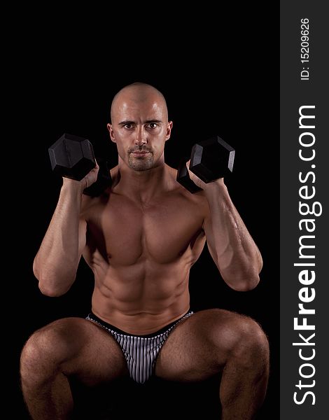 Muscle young man with dumbells in his hands