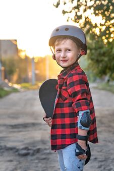 Happy Little Boy Standing On The Road Holding A Skate With His Hands. The Child Defended Himself, He Put On Hand Safety Gloves Stock Images