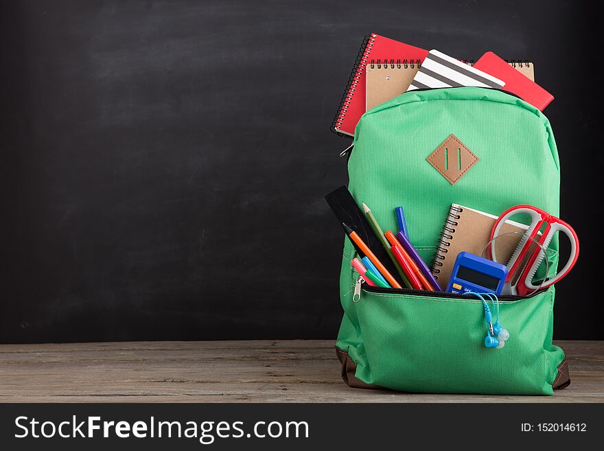 Education concept - school backpack with books and other supplies, bag, open, notebook, full, children, color, educational, haversack, knapsack, scribbler, stationary, pocket, large, pencil, calculator, standing, green, study, table, wooden, accessories, desk, red, equipment, group, learning, ruler, single, storage, teaching, tool, auditorium, classroom, chalkboard, blackboard, studying, scissors, copy, space. Education concept - school backpack with books and other supplies, bag, open, notebook, full, children, color, educational, haversack, knapsack, scribbler, stationary, pocket, large, pencil, calculator, standing, green, study, table, wooden, accessories, desk, red, equipment, group, learning, ruler, single, storage, teaching, tool, auditorium, classroom, chalkboard, blackboard, studying, scissors, copy, space