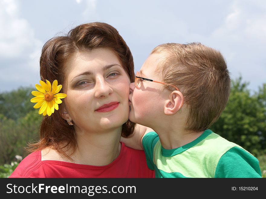 A little boy kisses his mom. A little boy kisses his mom