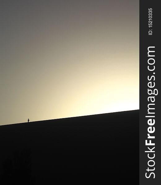 Landscape view of peole on the dune under sunset