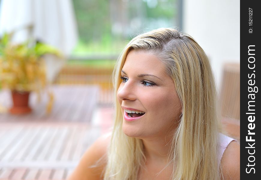 Young beautiful casual woman relaxing outdoors in the terrace of her home