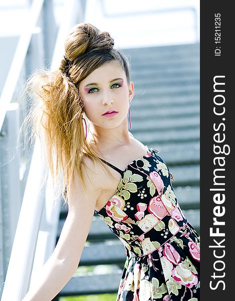 Teenager girl model presenting clothes in the park near the water and a bridge