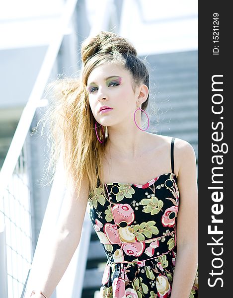 Teenager girl model presenting clothes in the park near the water and a bridge