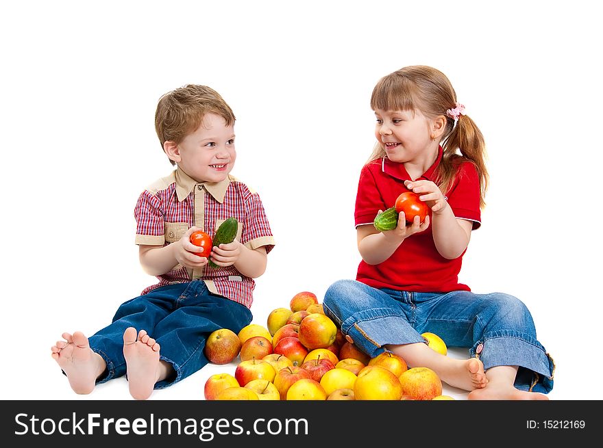 The girl and the boy with fruit and vegetables on white