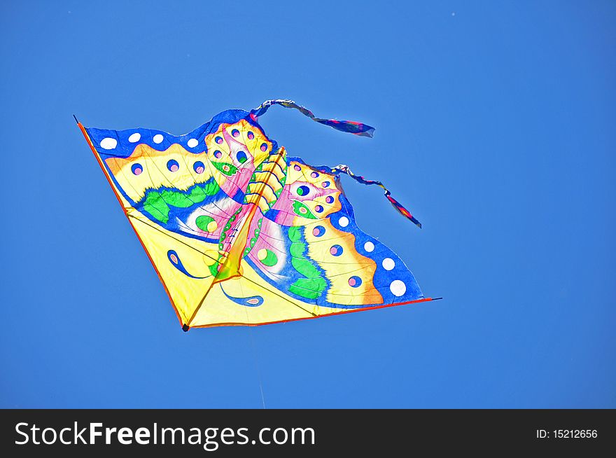 Colorful kite soaring in a blue sky. Colorful kite soaring in a blue sky