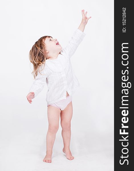 Studio porrait of cute child standing on toes pointing up