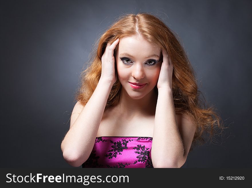 Beauty portrait of a sensitive red-haired woman holding head with hands