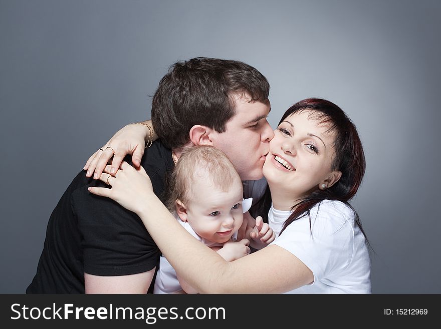 Closeup studio family portrait of a young loving couple with cute baby. Closeup studio family portrait of a young loving couple with cute baby