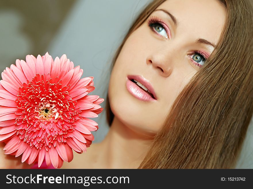 Portrait of young woman with flower. Focus on flower