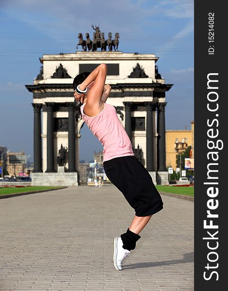 Woman modern ballet dancer in city against classic arch