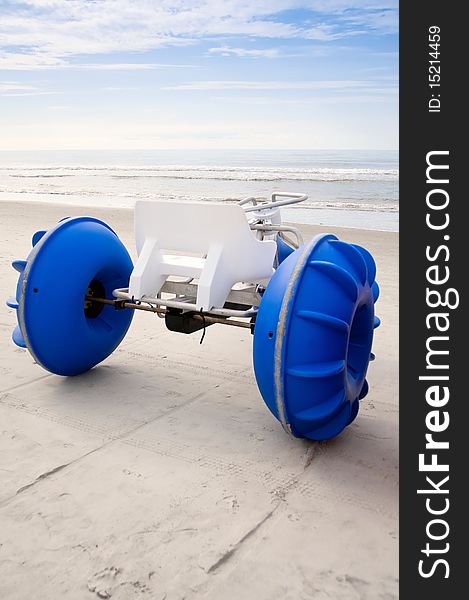 An amphibious beach toy with blue wheels against early morning sea and sky.