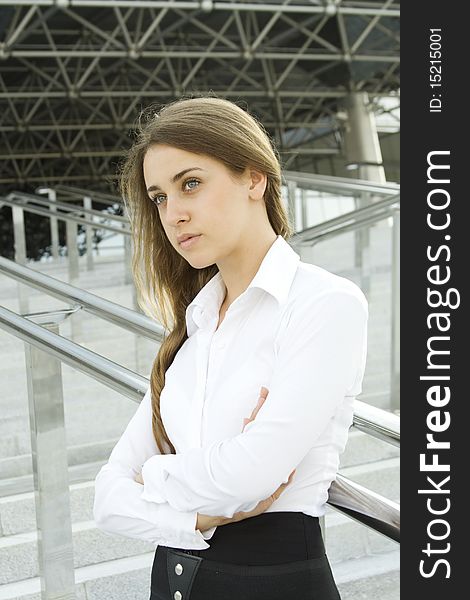 Contemporary portrait of a young professional business women to consider against the background of office space arms crossed. Contemporary portrait of a young professional business women to consider against the background of office space arms crossed