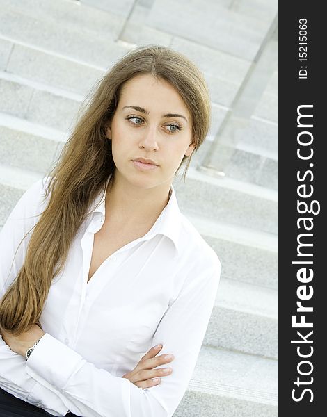 Contemporary portrait of a young professional business women to consider against the background of office space arms crossed. Contemporary portrait of a young professional business women to consider against the background of office space arms crossed