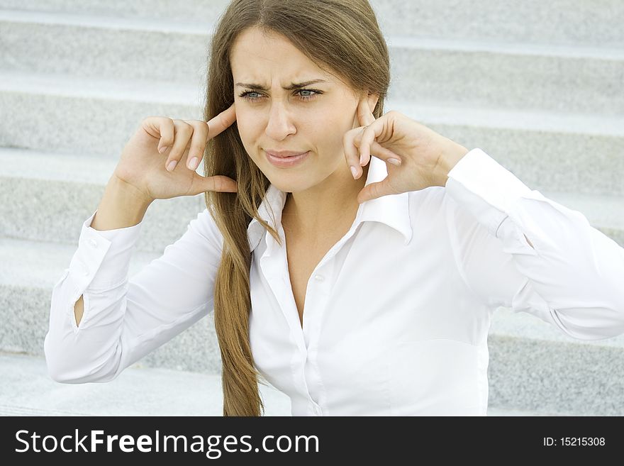 Young business woman plugs fingers in their ears. Young business woman plugs fingers in their ears