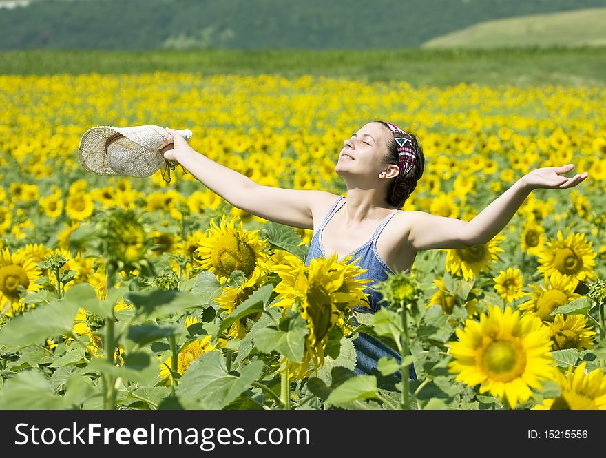 Young beautiful woman in a sunflower field. Young beautiful woman in a sunflower field