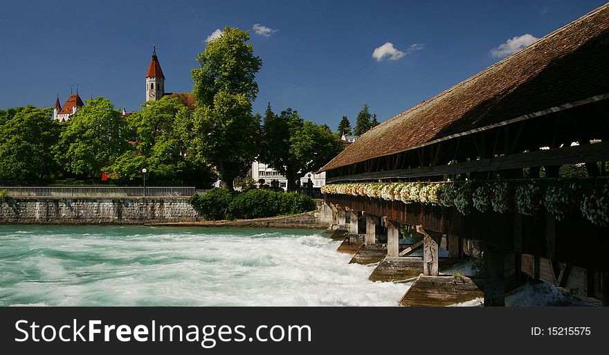 A barrage with a covered bridge is controlling the outflow of the Aare River from Lake Thun in the Swiss town of Thun.