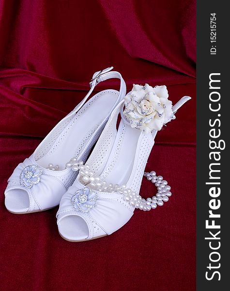 White wedding shoes on red background