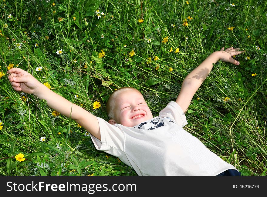 Child is lying on the grass and enjoying nature. Child is lying on the grass and enjoying nature