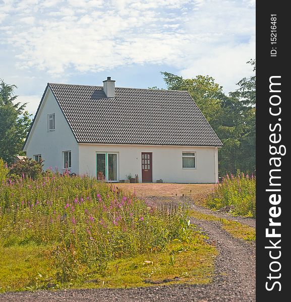 An image of a newly built  house with french doors at the front and with a chimney. An image of a newly built  house with french doors at the front and with a chimney.