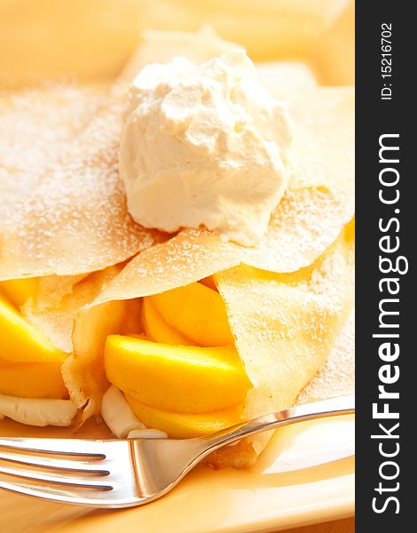 Peach crepes with a large dollop of whipped cream