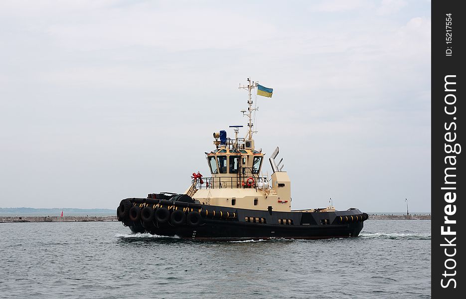 Tugboat moving at sea port area. Tugboat moving at sea port area