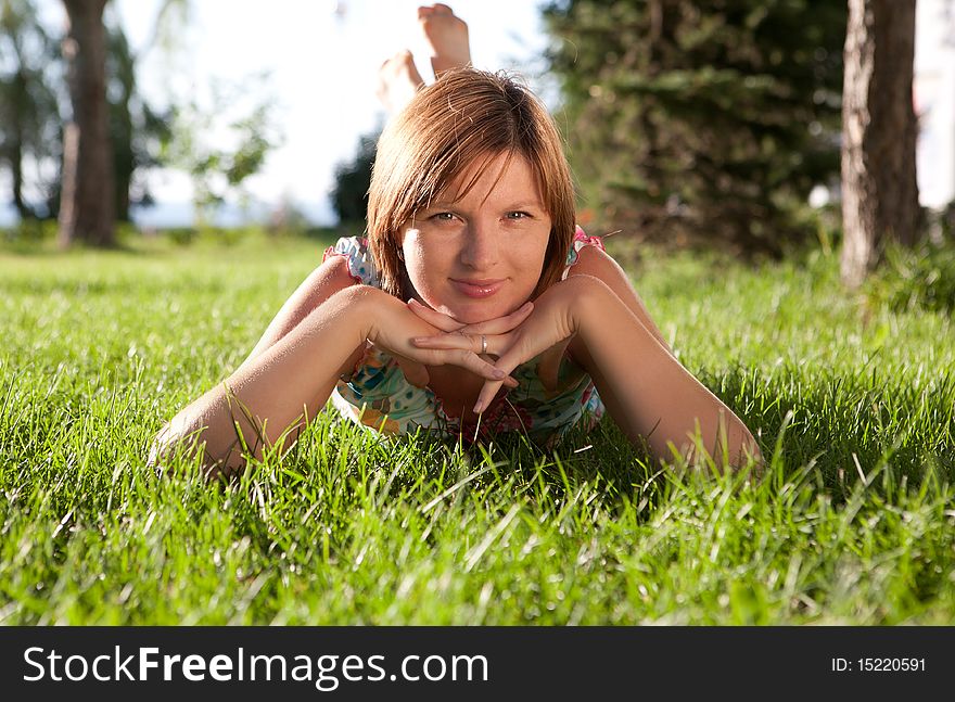 The girl having a rest on a grass in a sunny day