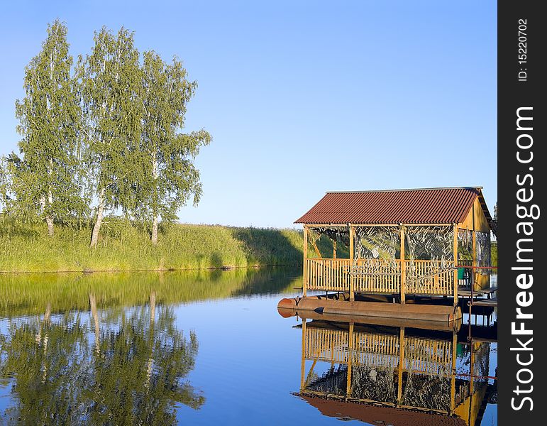 Small pond in the evening and old arbour on pontoons