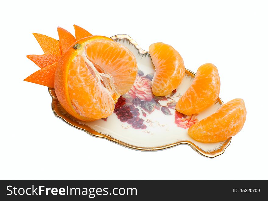 Orange tangerine devided into segments and decorated with peel on beauty fruit dish. Isolated on white background. Orange tangerine devided into segments and decorated with peel on beauty fruit dish. Isolated on white background