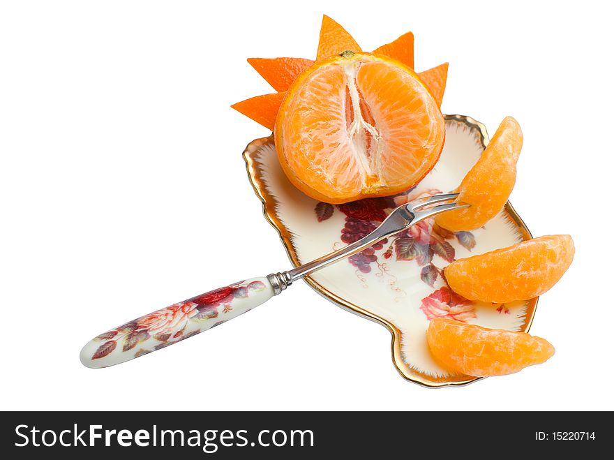 Orange tangerine devided into segments and decorated with peel on beauty fruit dish with fork. Isolated on white background. Orange tangerine devided into segments and decorated with peel on beauty fruit dish with fork. Isolated on white background