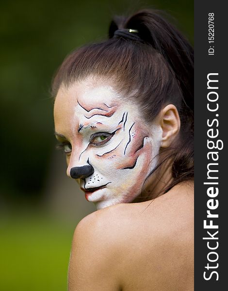 Young woman with tigress face art look at you