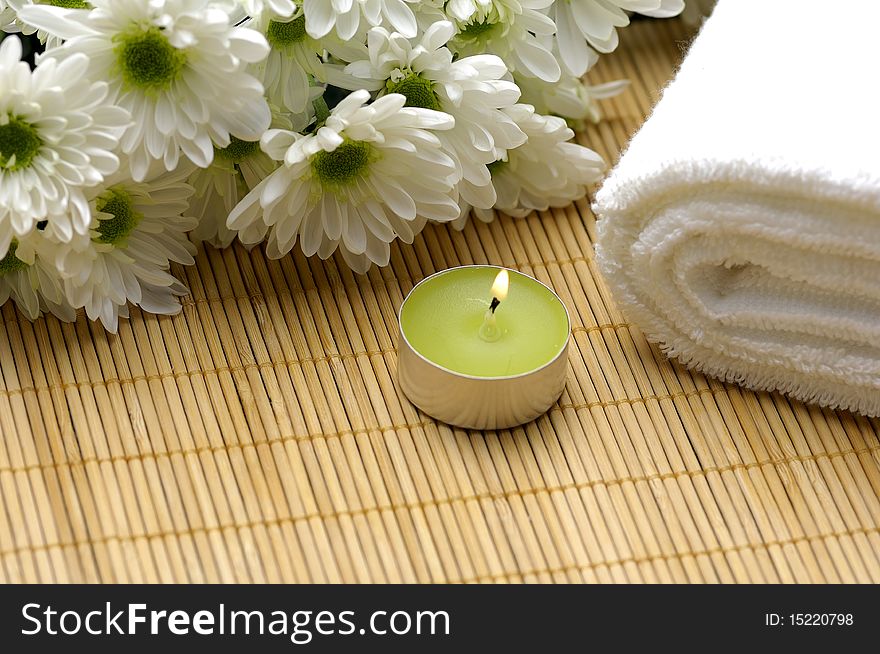 Spa composition. Towel, candle and chrysanthemums. Spa composition. Towel, candle and chrysanthemums