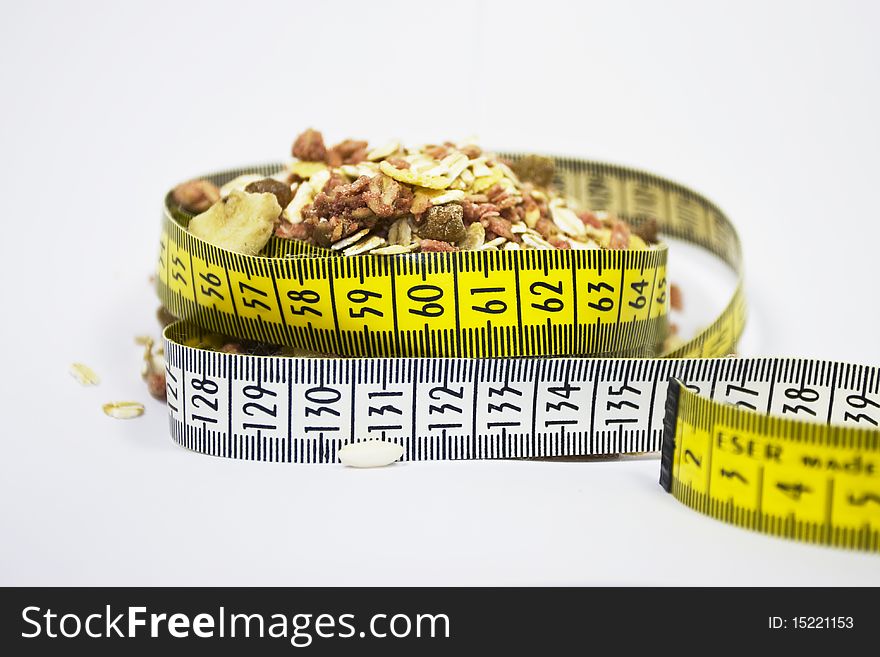 It is a small amount of cereals and a tape measure. It is a small amount of cereals and a tape measure