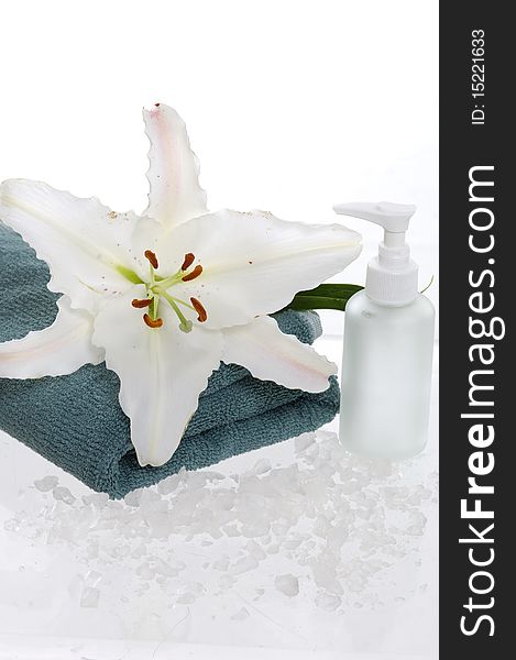 Bottles of shower gel with white lily on the white towel. Bottles of shower gel with white lily on the white towel