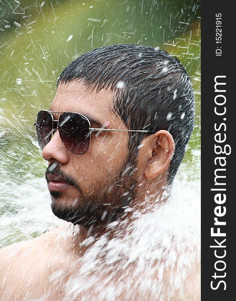 Close up of a man bathing under a waterfall