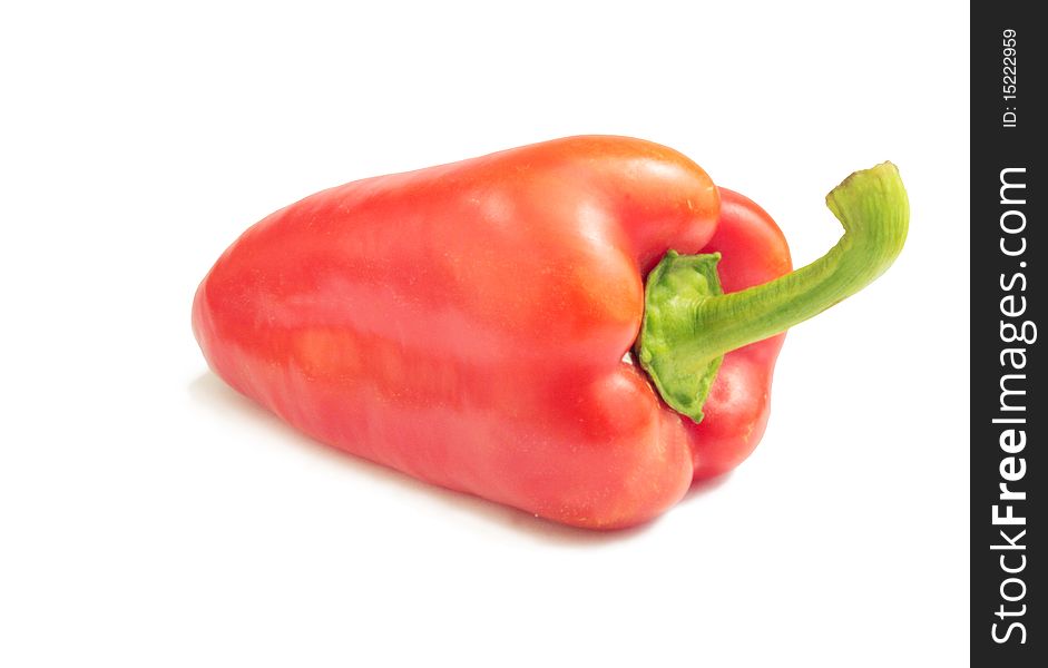 A big ripe red peppers with a long green ve on a white background. A big ripe red peppers with a long green ve on a white background