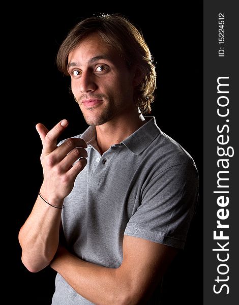 Young male model over black background with a grey shirt, with longer hair.