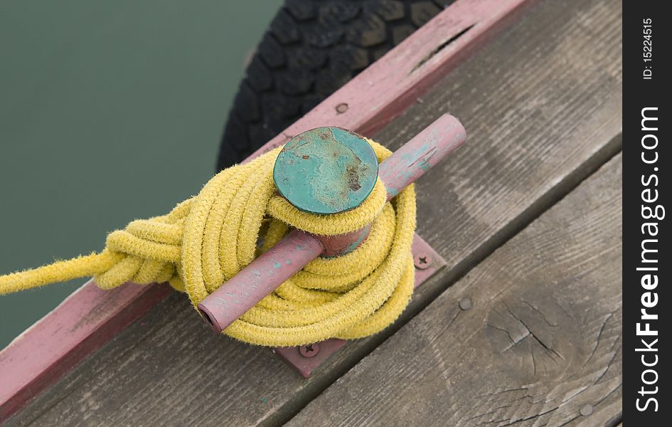 Yacht moored on yellow mooring rope on metal bollard. Yacht moored on yellow mooring rope on metal bollard