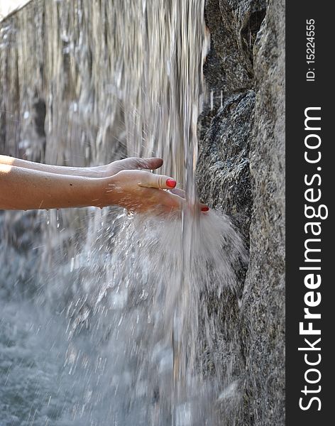 This photo shows a woman's hands in the fountain. This photo shows a woman's hands in the fountain