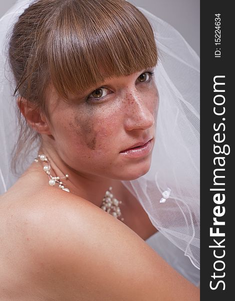 Portrait of sad bride over grey background