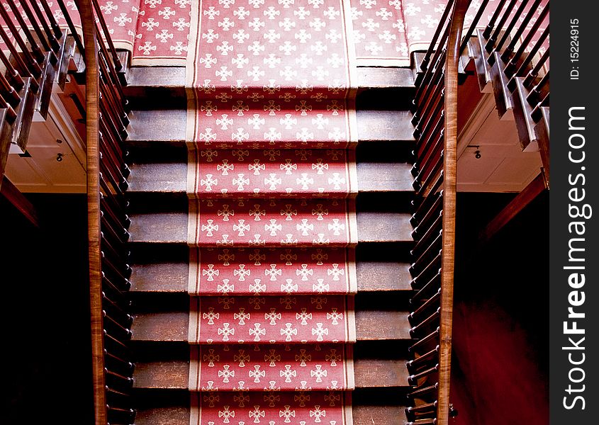 Old wooden imperial staircase with a red carpet