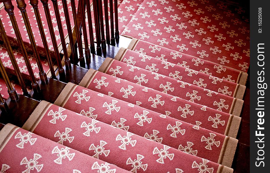 Old wooden imperial staircase with a red carpet